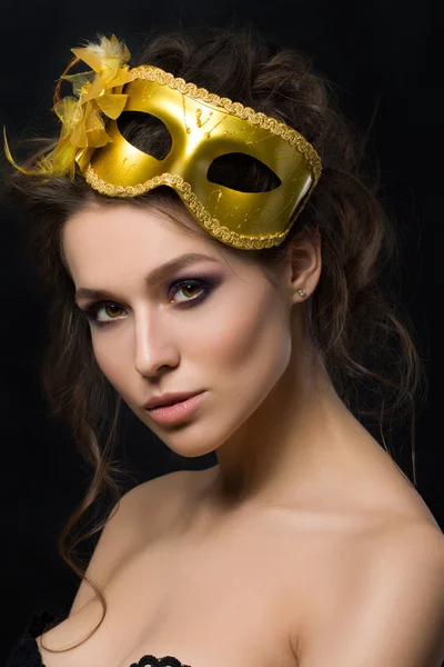 Portrait of young beautiful woman wearing golden party mask — 스톡 사진