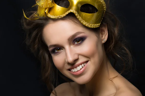 Portrait of young beautiful woman wearing golden party mask — 스톡 사진