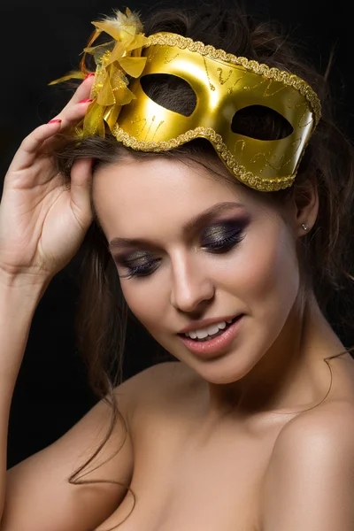 Portrait of young beautiful woman wearing golden party mask — 스톡 사진