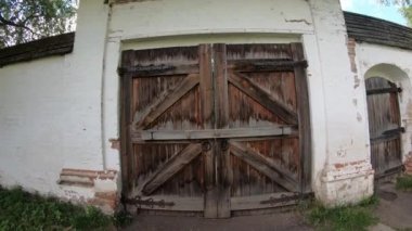 Büyük, eski ahşap kapı. Manastırın ortaçağ duvarı.