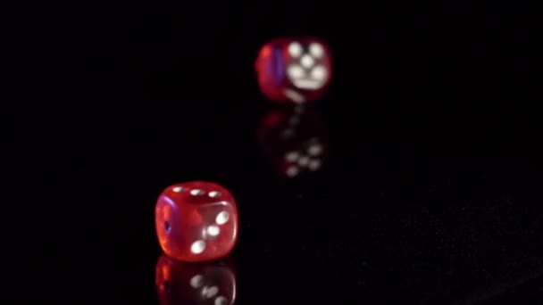 Pomalý pohyb válcování hracích kostek na černém stole.Rolling červené kasino kostky — Stock video