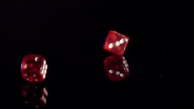 Siyah masada yavaş hareket eden oyun küpleri. Kırmızı kumarhane zarları.