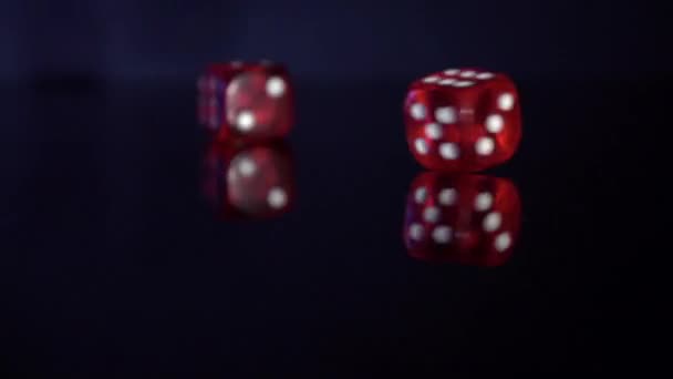 Movimiento lento de balanceo cubos de juego en la mesa negra.Rolling dados de casino rojo — Vídeo de stock