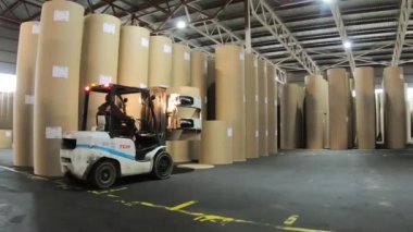 Şahin. Rusya-Ekim 2020::: Yükleyici depodaki karton balyaları paketliyor. Kağıt atıklarının geri dönüşümü.