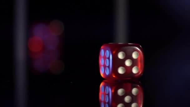 Movimiento lento de balanceo cubos de juego en la mesa negra.Rolling dados de casino rojo — Vídeo de stock