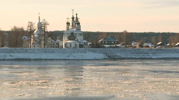 Православная церковь на берегу реки. Ледяной берег реки поздней осенью. — стоковое видео