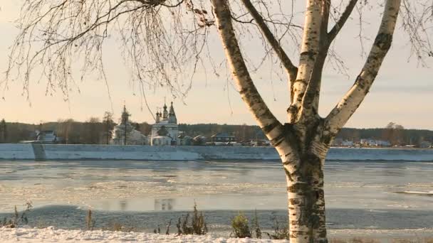 Ortodoxa kyrkan på flodbanken. Flodens istäckta strand under senhösten. — Stockvideo