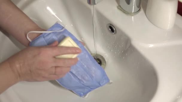 Washing a medical mask in the sink. Cotton reusable medical mask for protection from Covid-19. — Stock Video