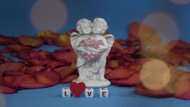 Dva roztomilí andělé a slovo láska na pozadí okvětních lístků růží .Valentines Day. Pohlednice na svátky — Stock video