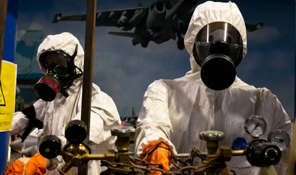 Personas con trajes de protección en el laboratorio para la producción de armas químicas y biológicas. — Foto de Stock