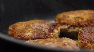 Et pirzolası pişiriyorum. Ev yemeği. Sulu et pirzolaları siyah bir tavada yağda kızartılır..