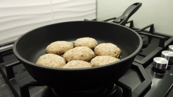 Vleeskoteletten koken. Thuis koken. Sappige vleeskoteletten worden in olie gebakken in een zwarte koekenpan. — Stockvideo