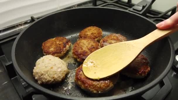 Pemasak daging potong. Masakan rumah. Potongan daging segar digoreng dalam minyak dalam wajan penggorengan hitam. — Stok Video