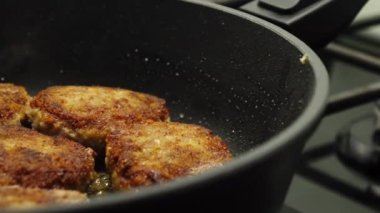 Et pirzolası pişiriyorum. Ev yemeği. Sulu et pirzolaları siyah bir tavada yağda kızartılır..