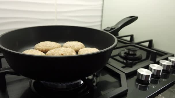 Cuisson des escalopes de viande. Cuisine maison. Côtelettes de viande juteuses sont frites dans l'huile dans une poêle noire. — Video