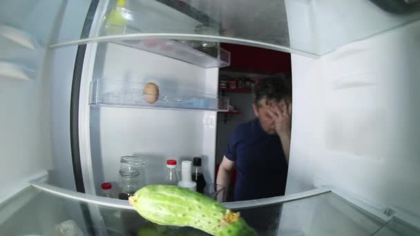 Nieogolony mężczyzna z kacem przeszukuje lodówkę w poszukiwaniu drinka i czegoś do jedzenia.. — Wideo stockowe