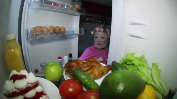 化粧品のマスクをした女性が食べ物の冷蔵庫を見て. — ストック動画