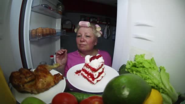 A woman looks in the refrigerator for food. — Stock Video