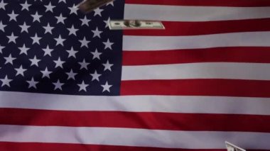 Amerikan bayrağının arka planına dolar düşmesi. Ağır çekimde. Para yağmuru.