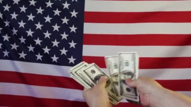 Amerikan bayrağının arka planına dolar düşmesi. Ağır çekimde. Para yağmuru.
