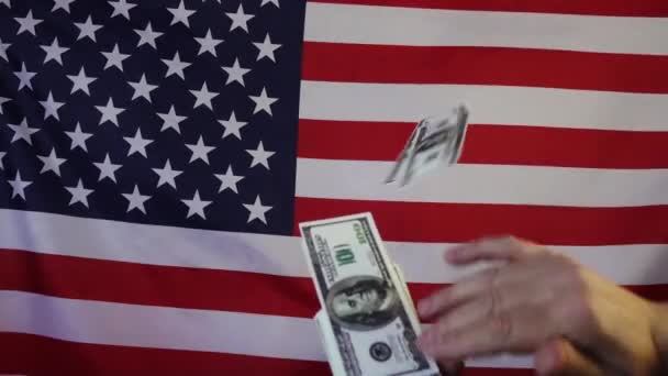 Dólares cayendo en el fondo de la bandera estadounidense. En cámara lenta. Lluvia de dinero. — Vídeo de stock