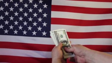 Amerikan bayrağının arka planına dolar düşmesi. Ağır çekimde. Para yağmuru.