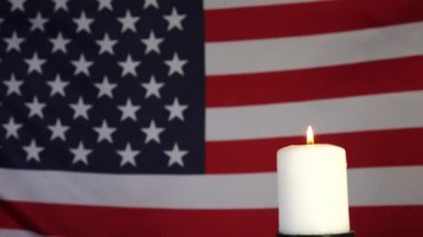 Amerikan bayrağının arka planında bir mum. Anma, kutlama ve yas günü.