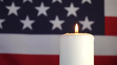 Amerikan bayrağının arka planında bir mum. Anma, kutlama ve yas günü.