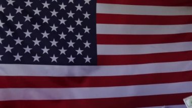 Amerikan bayrağının arka planına dolar düşmesi. Ağır çekimde. Para yağmuru.