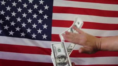 Amerikan bayrağının arka planına dolar düşmesi. Ağır çekimde. Para yağmuru.