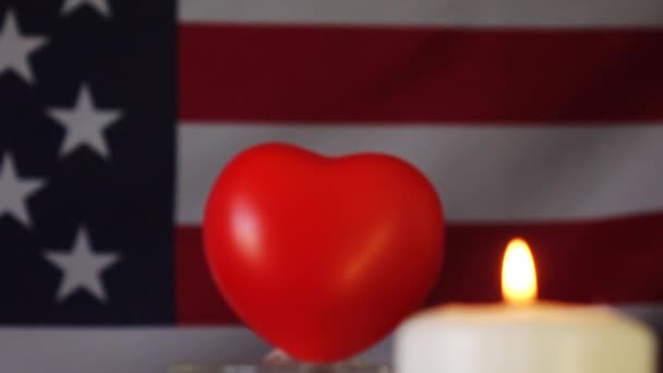 Una candela sullo sfondo della bandiera americana. Un giorno di ricordo, di festa e di lutto. — Video Stock