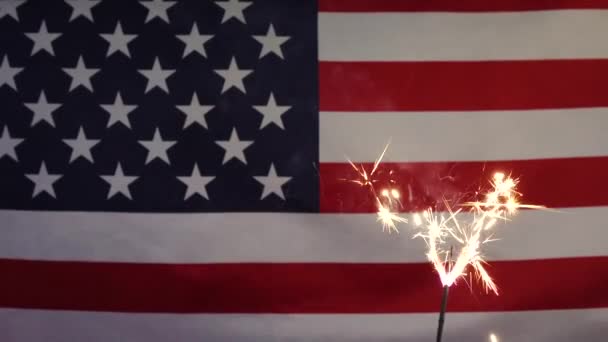 Una candela scintillante sullo sfondo della bandiera americana. — Video Stock