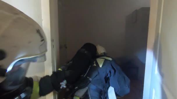 Brandweerlieden redden een man. Een team brandweermannen vindt het slachtoffer in de rook van het vuur en redt hem.. — Stockvideo