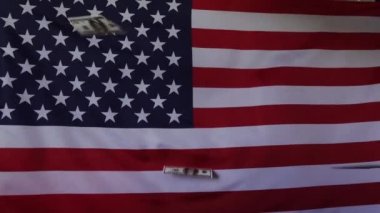 Amerikan bayrağının arka planına dolar düşmesi. Ağır çekimde. Para yağmuru.