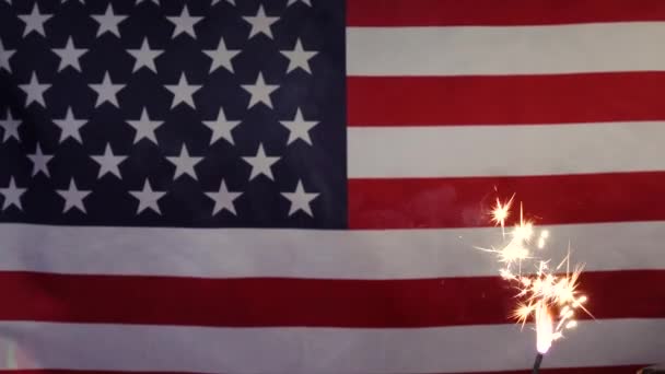 Una candela scintillante sullo sfondo della bandiera americana. — Video Stock