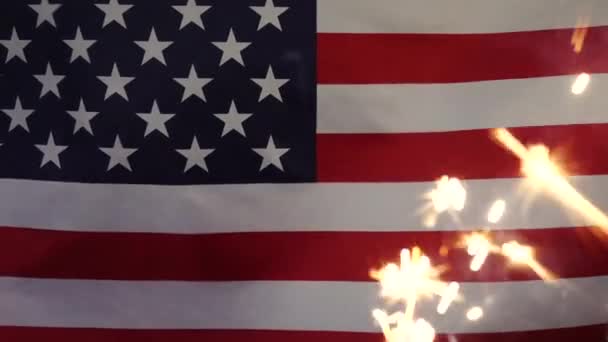 A sparkler candle on the background of the American flag. — Stock Video