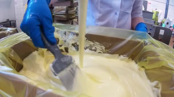 La mantequilla se vierte en una caja en la cremosa. Primer plano de un remolino de crema líquida fundida. — Vídeos de Stock