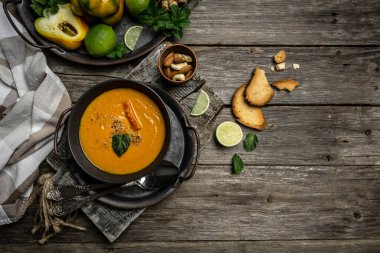 Balkabağı ve havuç çorbası fırında biber ve peynir, limon suyu ve siyah tabakta zencefil..