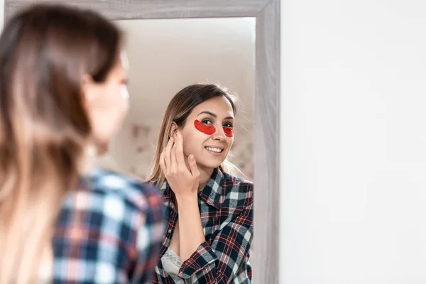 Pengobatan Kulit Mata Tersenyum Wanita Menerapkan Patch Merah Bawah Mata — Stok Foto