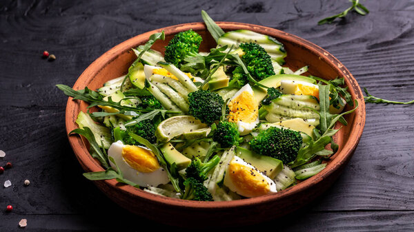 Healthy organic vegan salat with egg, avocado and mixed fresh vegetables on black background top view. Healthy meal concept, Food recipe background. Close up.