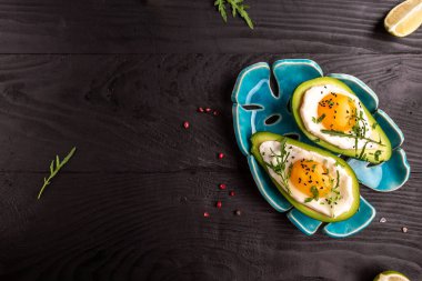 Avokado 'da tuzlu ve biberli ev yapımı organik yumurta. Yumurtayla doldurulmuş avokado. Lezzetli kahvaltı ya da atıştırmalık. en üstteki görünüm.