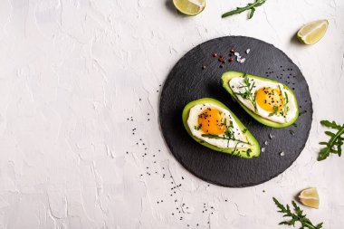 Avokado sahanda yumurta, lezzetli kahvaltı ya da arka planda atıştırmalık, üst manzara..