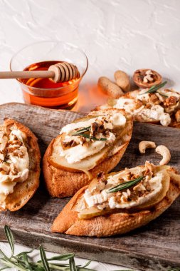 İtalyan antipatik atıştırmalıklarıyla aperatifler. Bal, ceviz ve biberiyeli armut ve brie crostini..