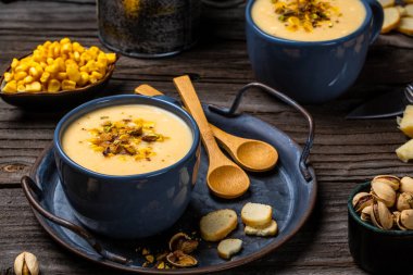 Mısır çorbası, vejetaryen mutfağı. Geleneksel sonbahar mısır çorbası. Mısır koçanı, kavrulmuş şam fıstığı ve kızarmış ekmek, restoran menüsü, diyet, yemek kitabı tarifi, üst görünüm....