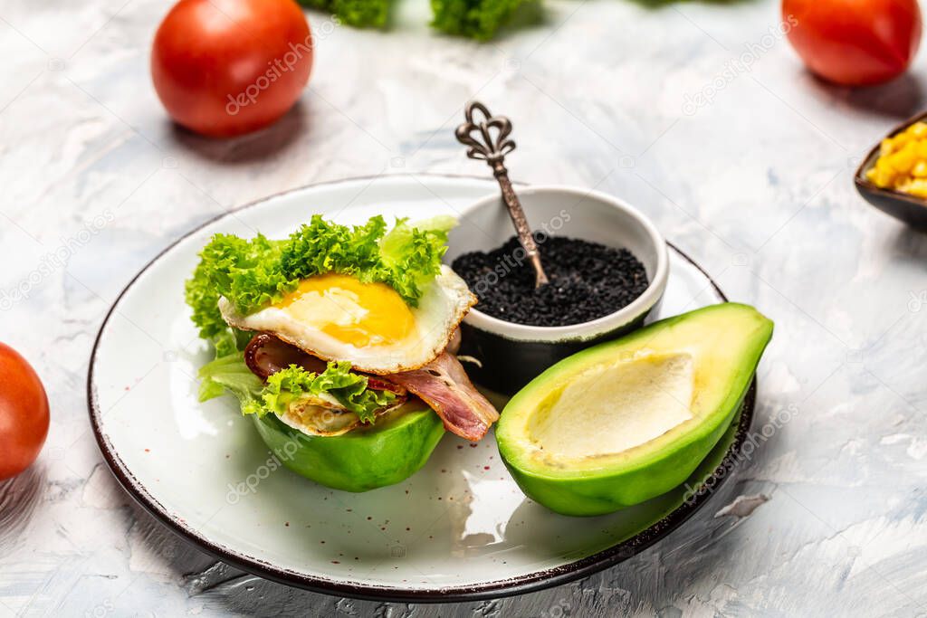 Trendy Raw Vegan avocado burger with fesh vegetables and bacon, egg, Ketogenic diet breakfast. Keto, paleo lunch, Copy space for text.