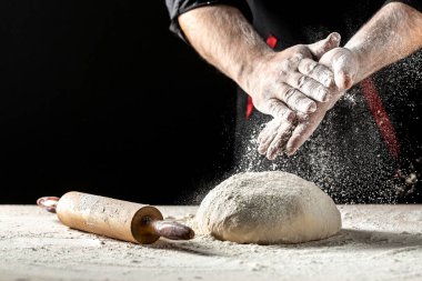 Un ve un serpintili erkek eli fotoğrafı. Ekmek pişiriyorum. Hamuru yoğurmak