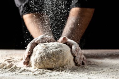 Güzel ve güçlü erkeklerin elleri hamuru yoğurarak ekmek, makarna ya da pizza yaparlar. Bir un bulutu toz gibi uçuşuyor. Yiyecek konsepti