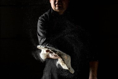 Şefin elleri arka planda hamur pişiriyor. Şef pizza için para kusuyor. Şef para kazanıyor. Un sıçraması. Ekmek pişiriyorum. Hamuru yoğurmak.