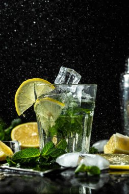 Taze, parlak yaz kokteyli. Limonlu, limonlu ve naneli mojito kokteyli. Sıvı sıçramalı taze içecek, koyu arka plandaki kavanoz bardağında dondurucu hareket. Limonlu mojito..