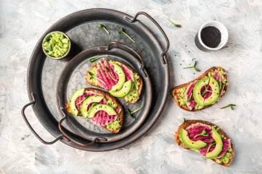 Dilimlenmiş karpuz turpu ve avokadodan yapılmış sağlıklı kahvaltı tostları. Pankart, yemek servisi menü tarifi yeri, metin, üst görünüm.